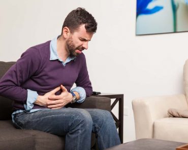 Profile view of a guy touching his belly and having a stomach ache at home antoniodiazs 370x297 1