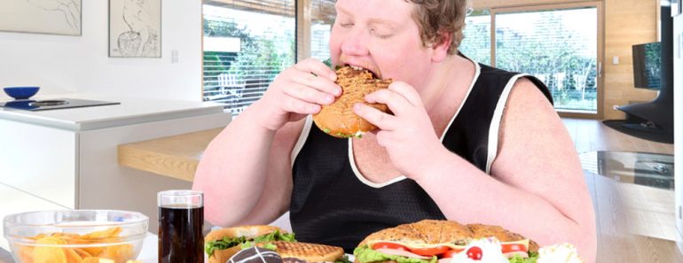 Fat man overeating food of full table 770x297 1