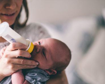 Little new born baby drinking bottle milk 370x297 1