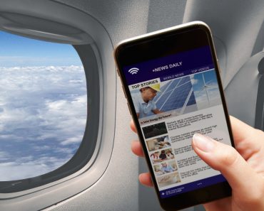 Mobile in girl hand reading news connected to the airplane wifi window cloud flying 370x297 1